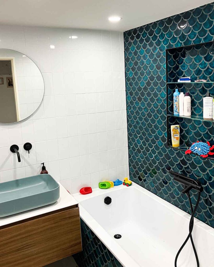 Ceramic mosaic tiles - fish scales, petrol blue color, bathroom wall above the bathtub